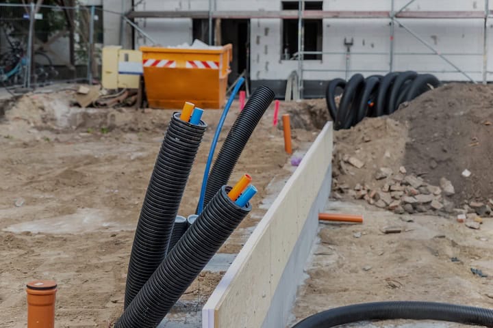 Black PVC flexible corrugated plastic insulation pipes tubing of electrical cables wire at undeground installation. New modern building construction site with engineering pipeline drainage technology